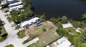 An aerial view shows a rectangular waterfront lot outlined in red next to a house — 6981 EDGEWATER DRIVE, NEW PORT RICHEY, FL