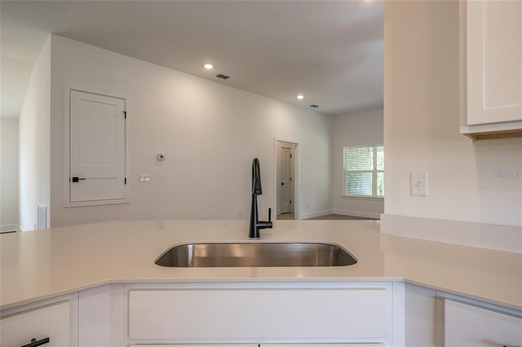 A kitchen sink with a dark faucet is set into a white countertop — 32 RYMSHAW DRIVE, PALM COAST, FL