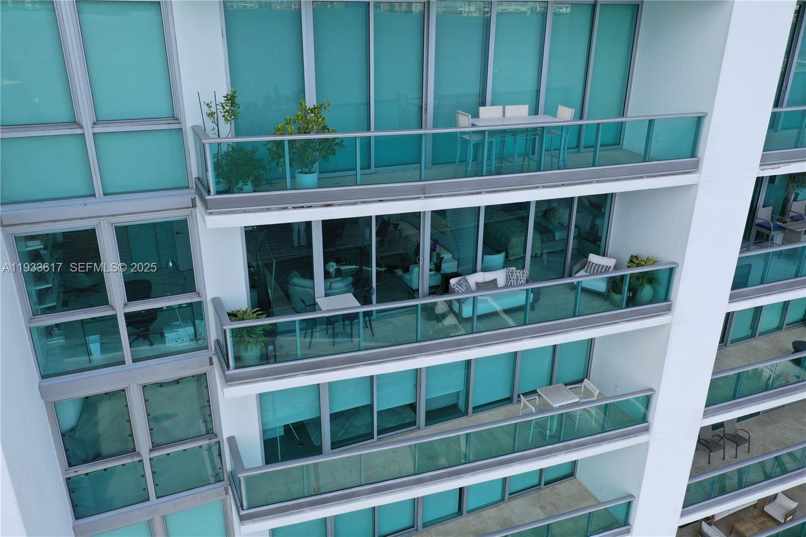 An exterior view shows multiple stacked balconies with glass railings on a modern high-rise building — 1331 Brickell Bay Dr # 1609, Miami FL 33131, MIAMI, FL
