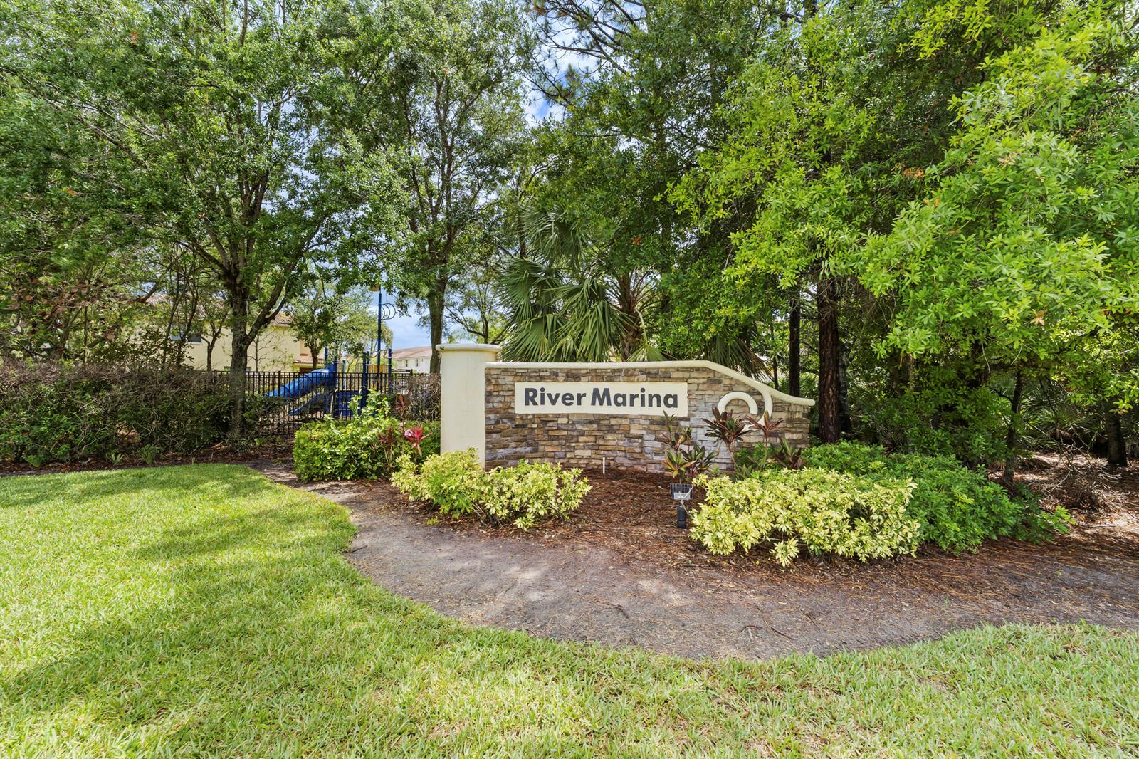A stone monument sign for River Marina stands in a landscaped area with mature trees — 3051 SW Otter Lane, Stuart FL 34997, STUART, FL