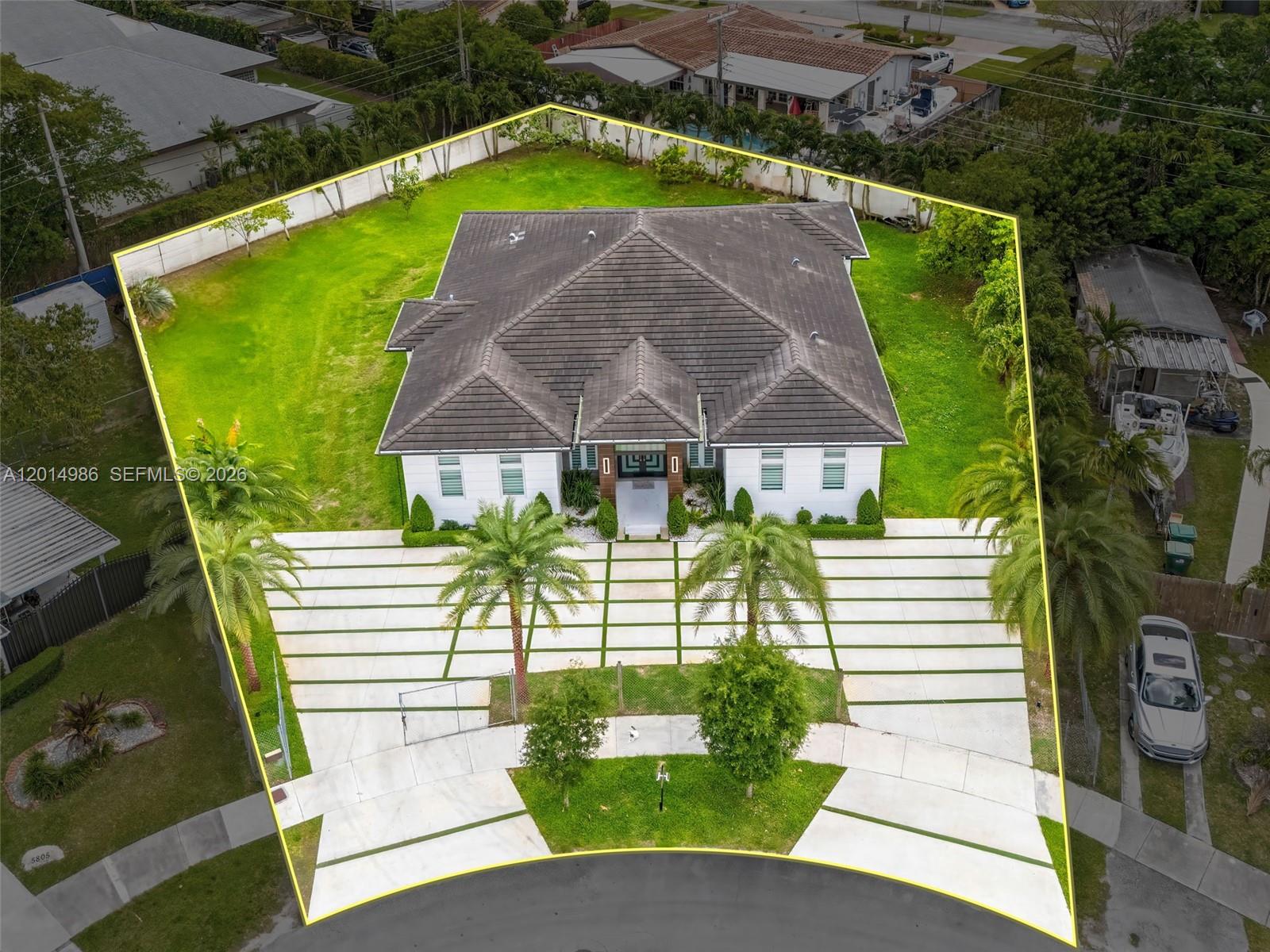 An aerial view shows a single-story house with a large driveway and expansive grassy yard — 5815 SW 107th Pl, Miami FL 33173, MIAMI, FL