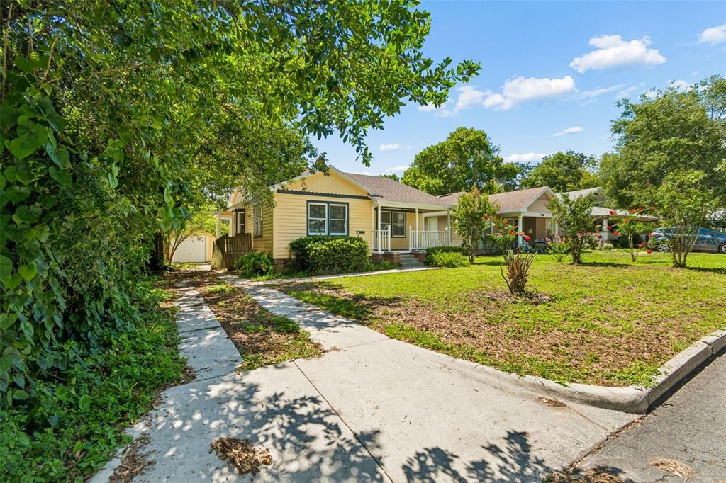 A yellow single-story house with a front porch and a concrete driveway — 1019 S TENNESSEE AVENUE, LAKELAND, FL