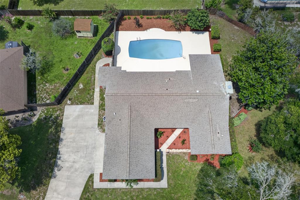 An aerial view shows a house with a shingled roof, a pool, and a shed — 2704 BURGOYNE PLACE, DELAND, FL