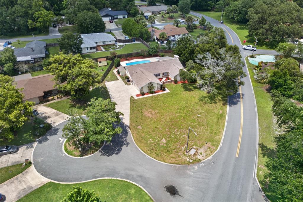 An aerial view shows a single-story house with a pool and a circular driveway — 2704 BURGOYNE PLACE, DELAND, FL