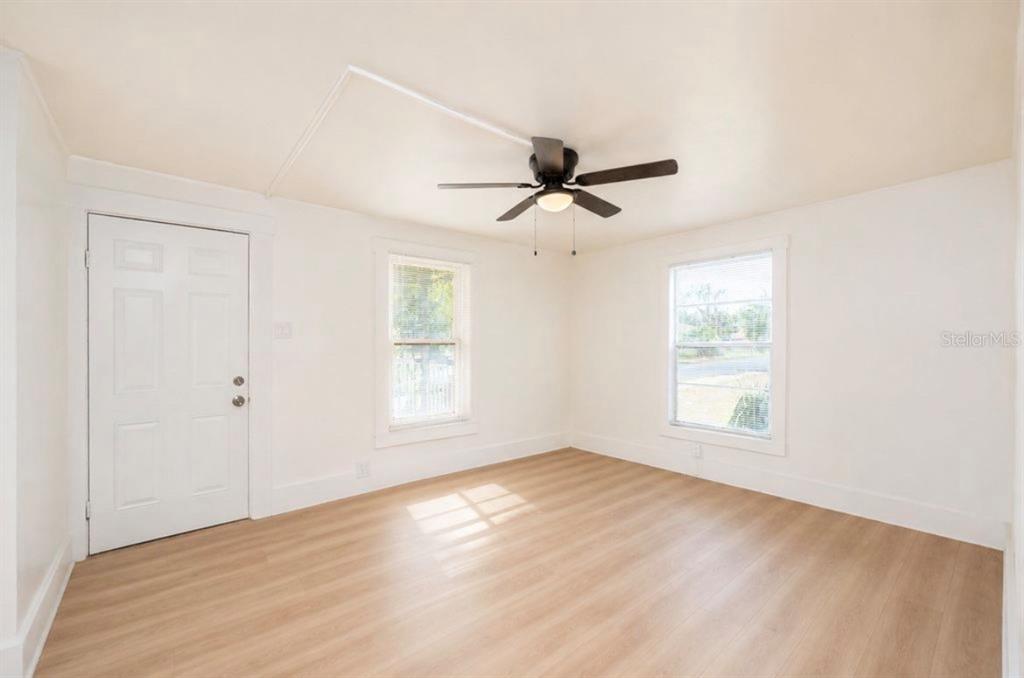 A room with light gray walls, wood-look flooring, a ceiling fan, and white storage furniture — 1701 14TH STREET S UNIT B, ST PETERSBURG, FL