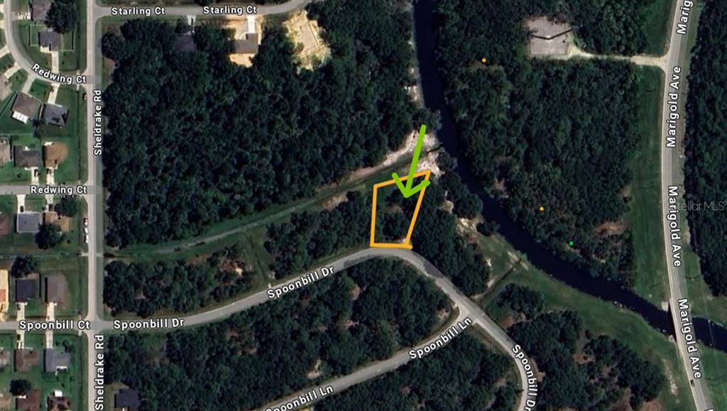 This is a satellite map view showing a vacant lot outlined in orange — 268 SPOONBILL DRIVE, KISSIMMEE, FL