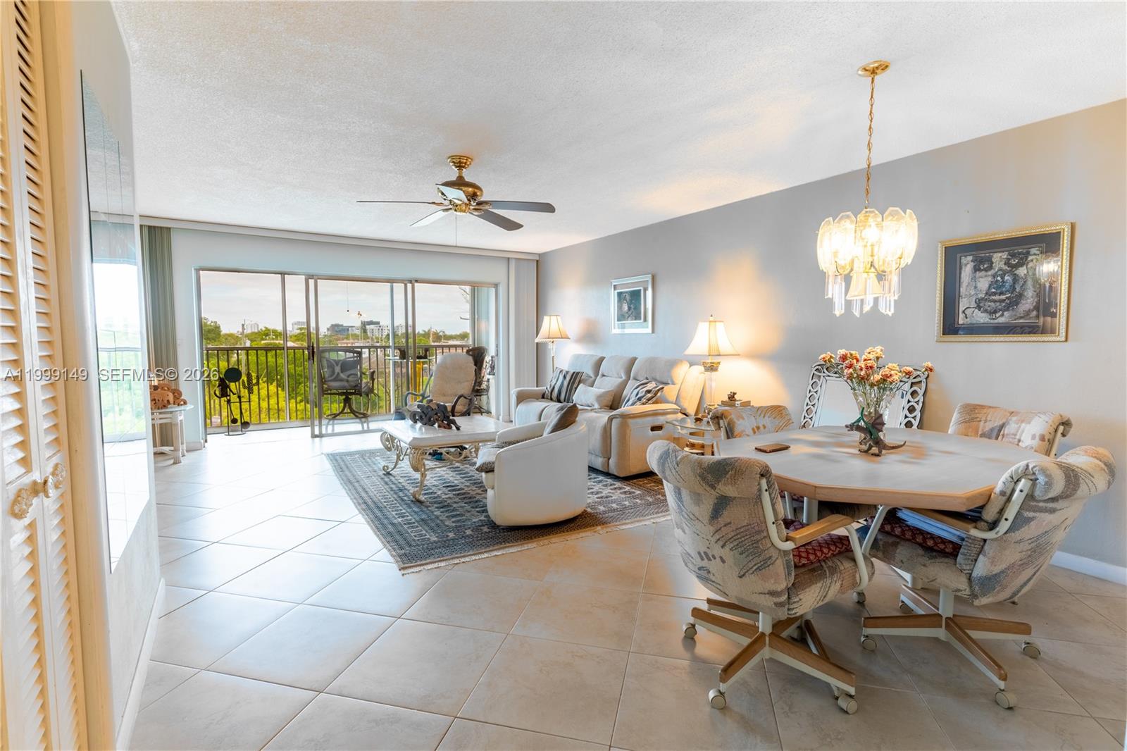 A living and dining area features tile floors, a ceiling fan, and a balcony view — 330 SE 2nd St # 405F, Hallandale Beach FL 33009, HALLANDALE BEACH, FL