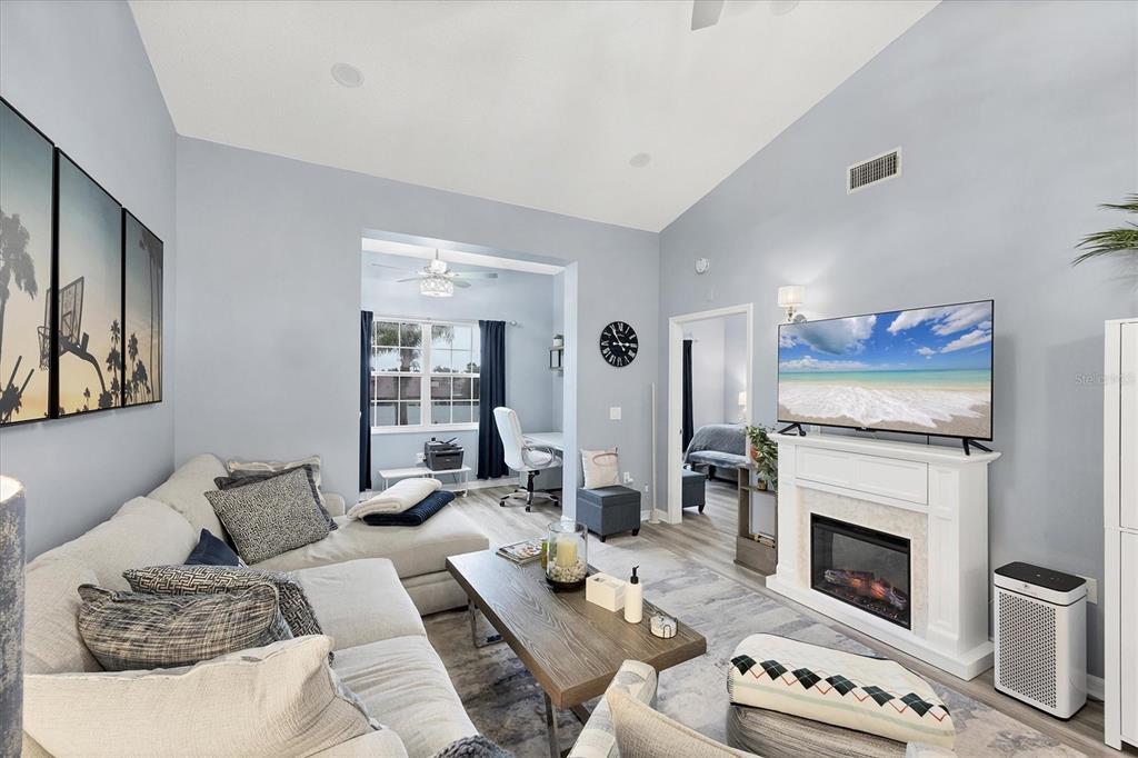 A living room features a sectional sofa, a fireplace with a television, and an office nook — 3701 54TH DRIVE W UNIT 202, BRADENTON, FL