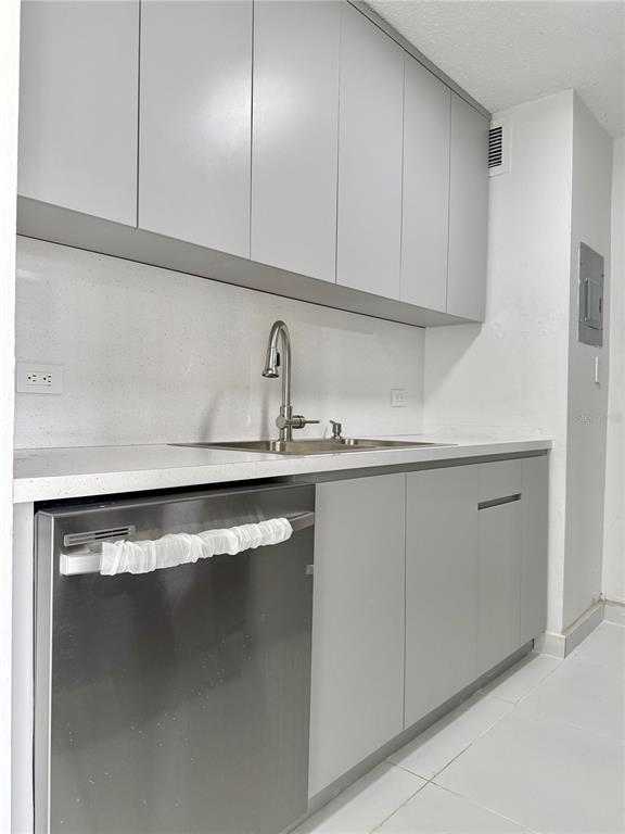 A kitchen features gray flat-panel cabinets, a stainless steel dishwasher, and a white countertop — 14 AVE.SAN PATRICIO UNIT 1004, GUAYNABO, PR