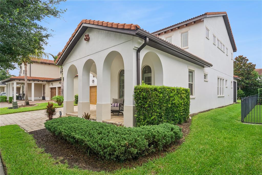 A white two-story house with a tiled roof and a three-arched covered front porch — 15709 SHOREBIRD LANE, WINTER GARDEN, FL