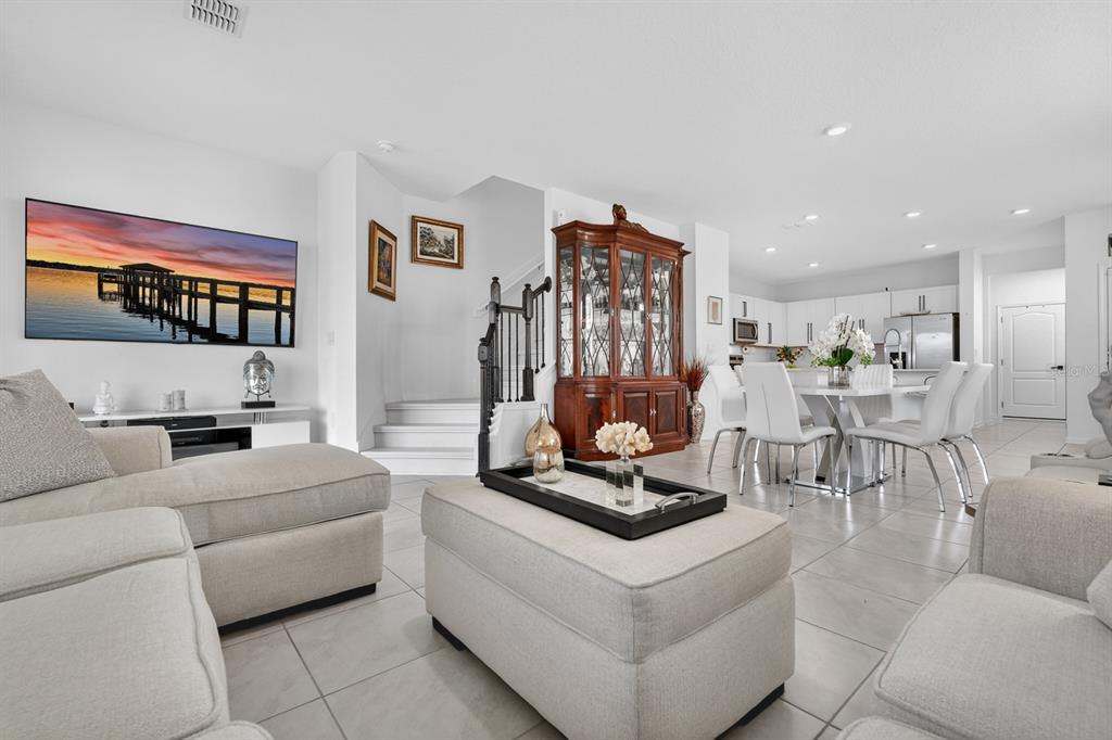 A bright, open-concept living and dining area features light tile flooring and white walls — 336 REDBUD ROAD, PALM COAST, FL