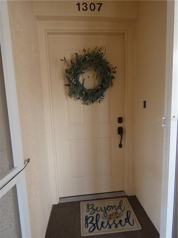 A front door with a wreath and a welcome mat labeled 1307 above it — 9300 CLUBSIDE CIRCLE UNIT 1307, SARASOTA, FL