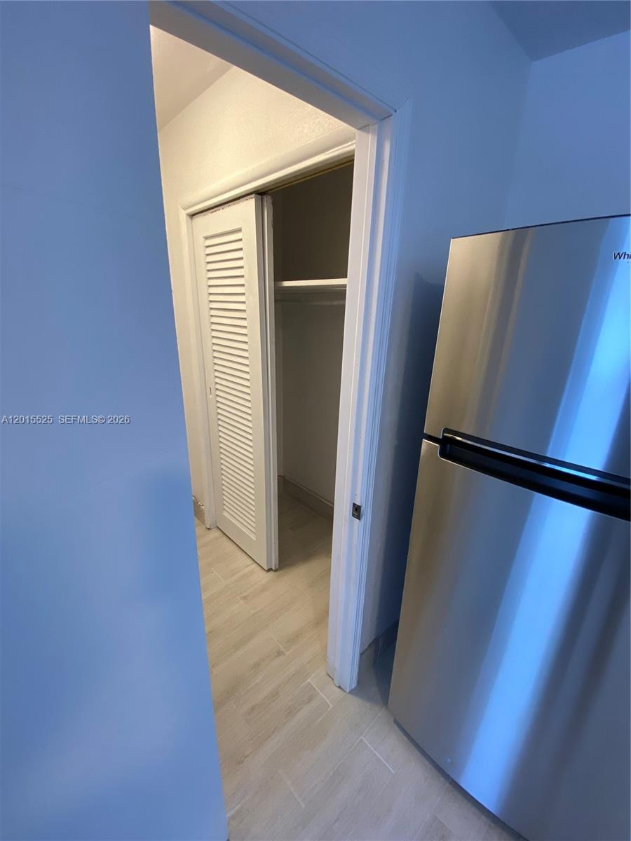 A stainless steel refrigerator stands next to an open doorway leading to a small closet — 1723 Liberty St # 6, Hollywood FL 33020, HOLLYWOOD, FL