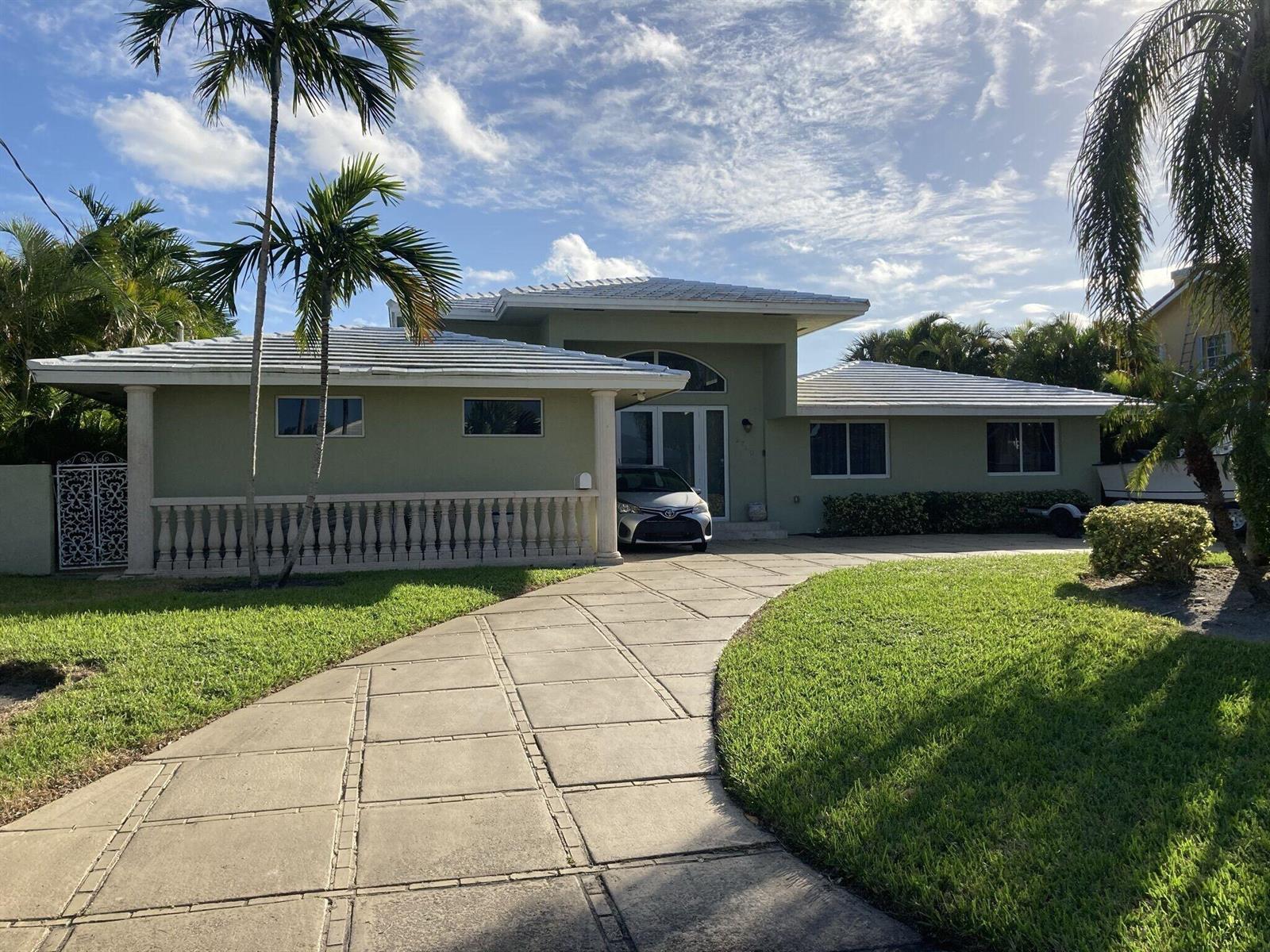 A single-story house with a light green exterior, a tiled roof, and a paved driveway — 2740 NE 10th Street, Pompano Beach FL 33062, POMPANO BEACH, FL