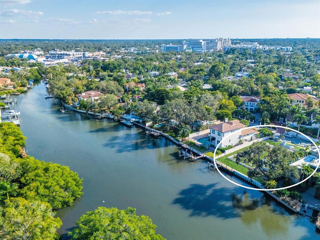 An aerial view shows a waterfront house with a pool and a large fenced yard — 1821 LINCOLN DRIVE, SARASOTA, FL