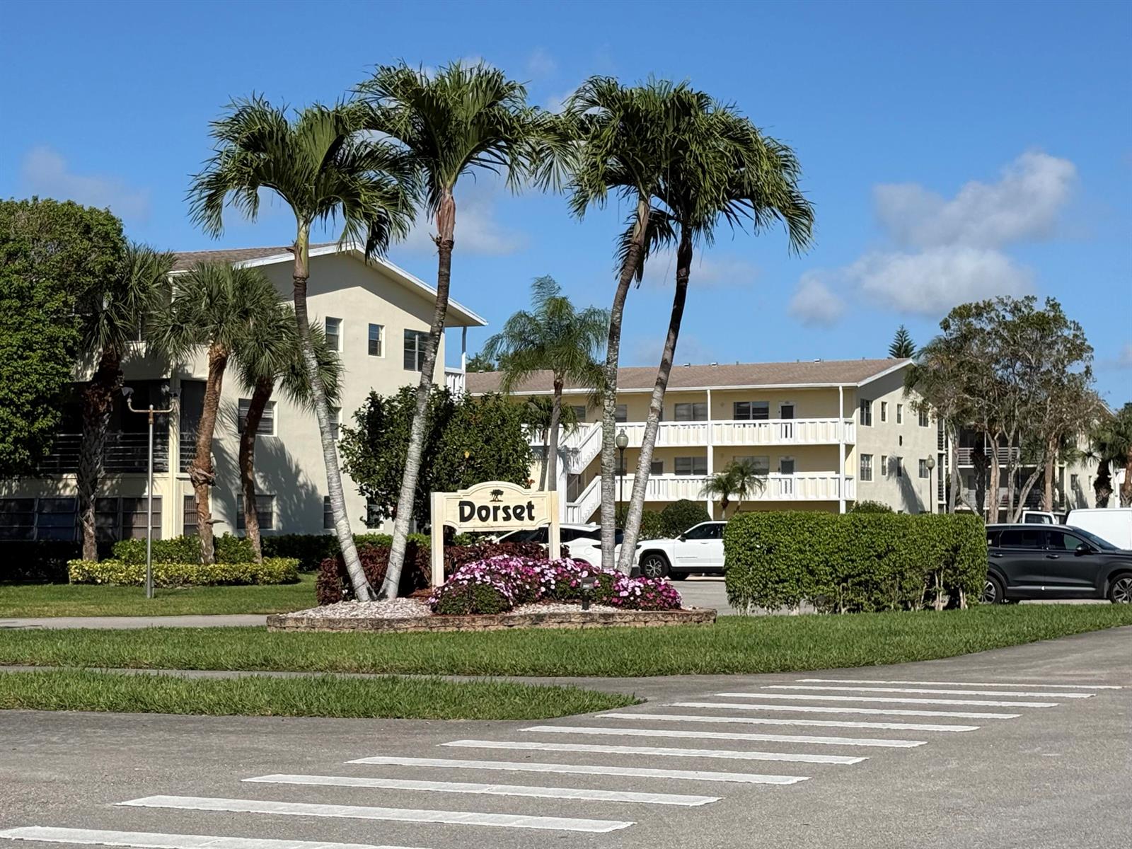 A sign for Dorset stands in front of multi-story apartment buildings and palm trees — 13 Dorset A, Boca Raton FL 33434, BOCA RATON, FL