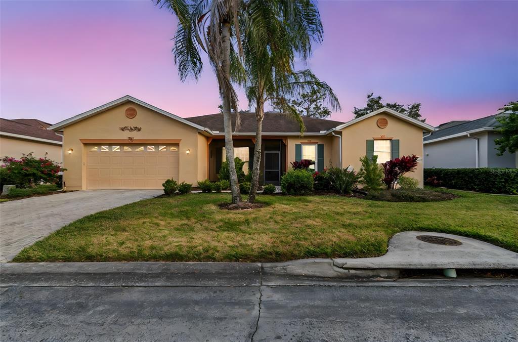A single-story house with a two-car garage, palm trees, and a landscaped front yard — 305 ROCK SPRINGS DRIVE, KISSIMMEE, FL