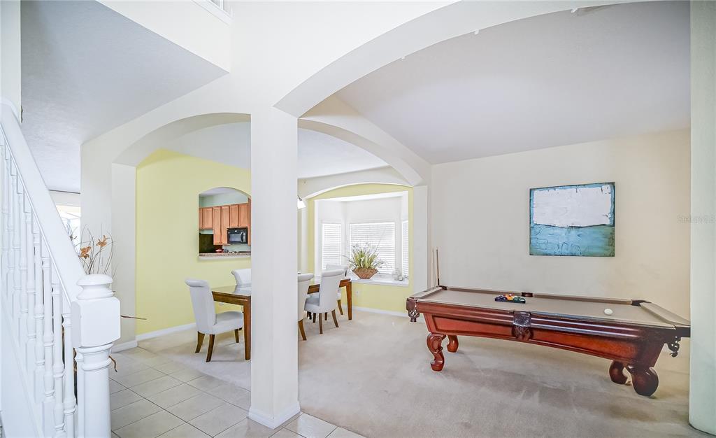 A room with a pool table, dining area, and arched architectural details — 1009 ORANGE COSMOS BOULEVARD, DAVENPORT, FL