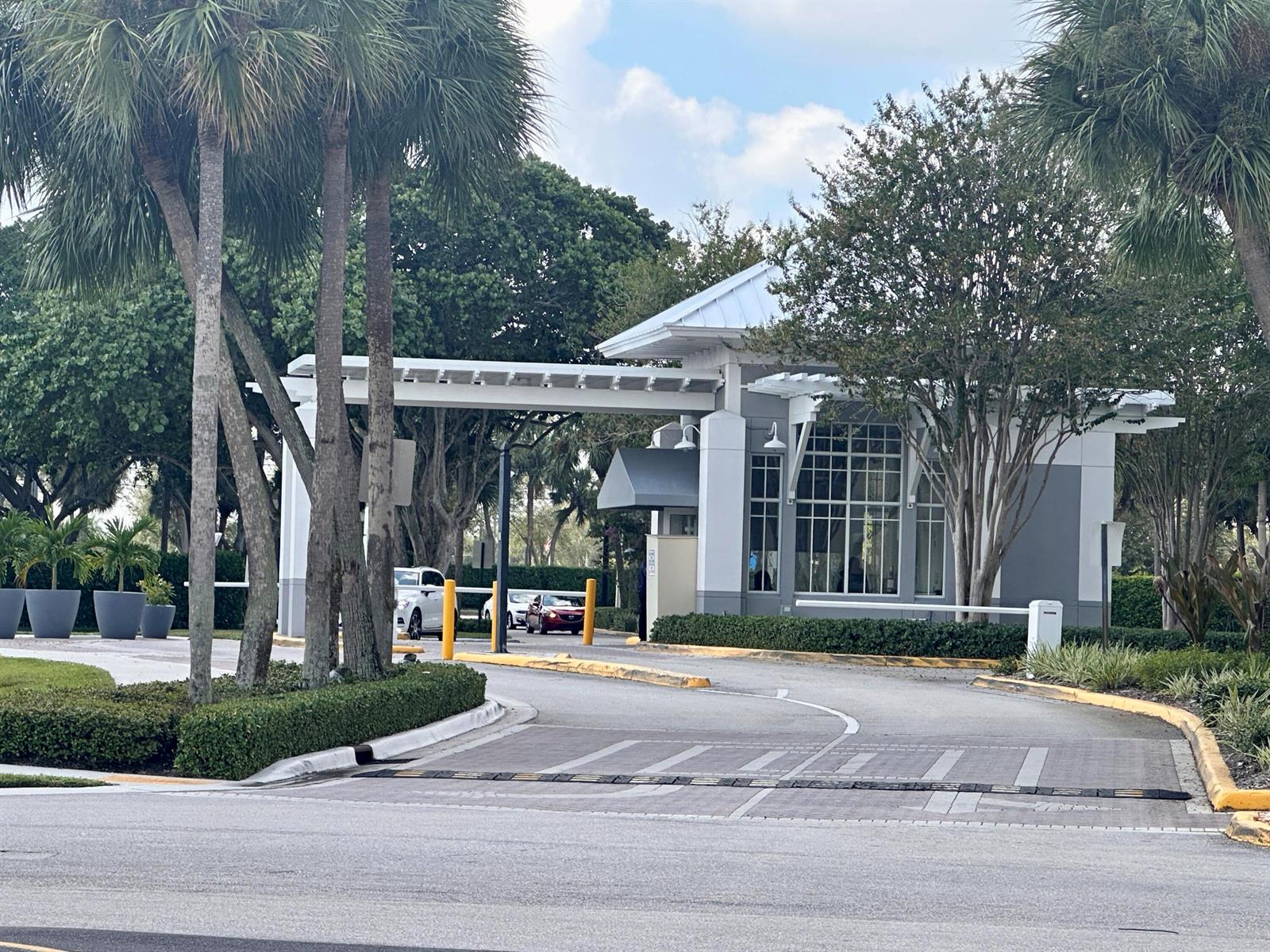 A gated community entrance features a guardhouse with a white pergola and palm trees — 750 Burgundy P, Delray Beach FL 33484, DELRAY BEACH, FL