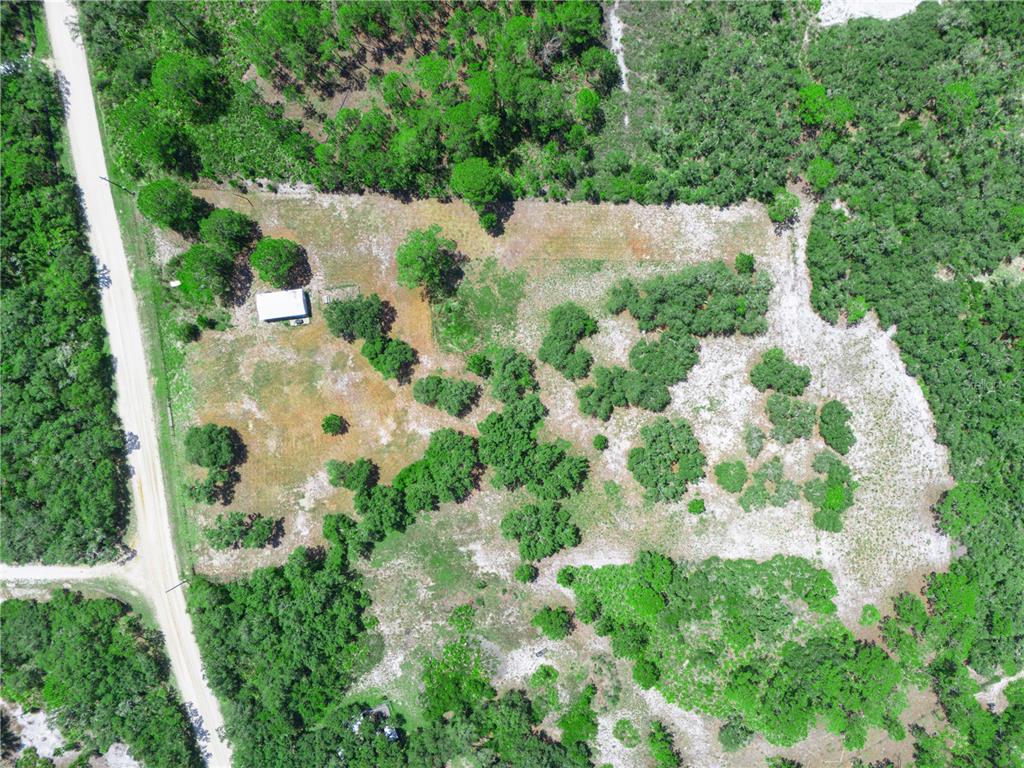 An aerial view shows a rectangular plot of land with a small building and trees — 1202 R E BYRD RD, FROSTPROOF, FL