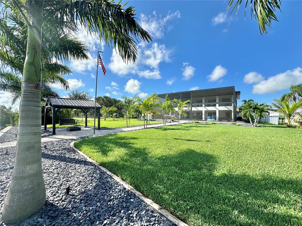A two-story house exterior features a pool, a screened-in patio, and a balcony at dusk — 2424 HARBOUR DRIVE, PUNTA GORDA, FL
