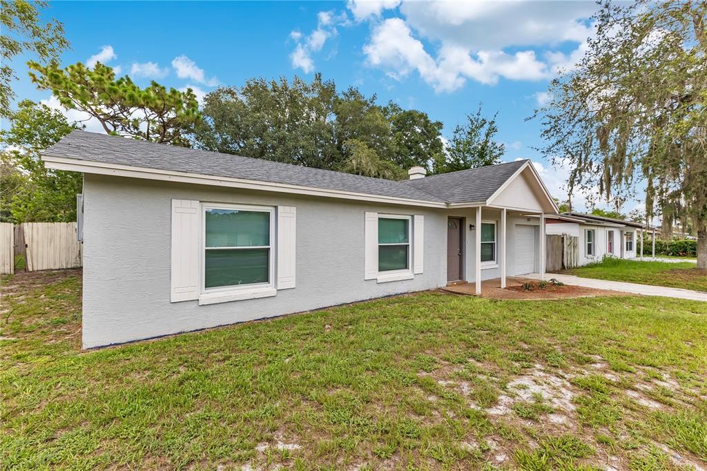 A single-story gray house with a shingled roof and a small front porch — 1111 CABALLERO ROAD, OCOEE, FL