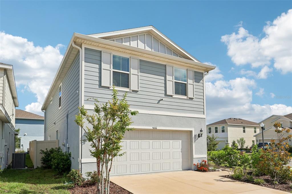 A two-story house with light blue siding, a two-car garage, and a concrete driveway — 5016 BLUE HAMMOCK COURT, KISSIMMEE, FL