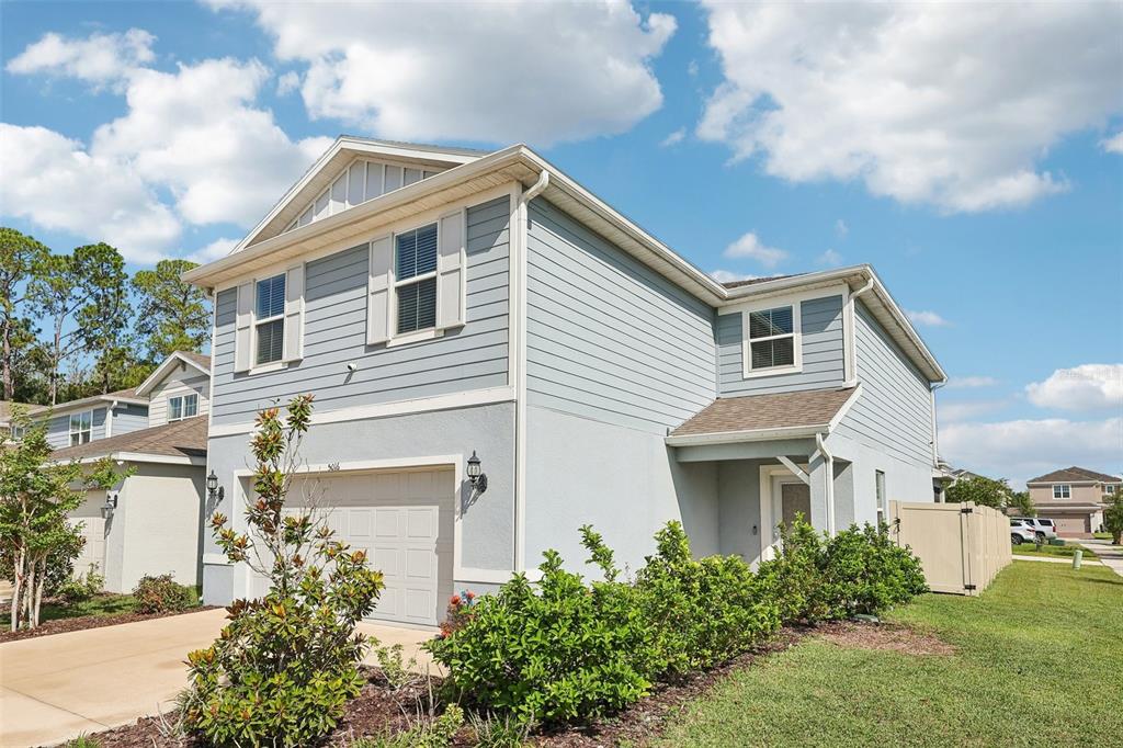 A two-story house with light blue siding, a garage, and a landscaped front yard — 5016 BLUE HAMMOCK COURT, KISSIMMEE, FL