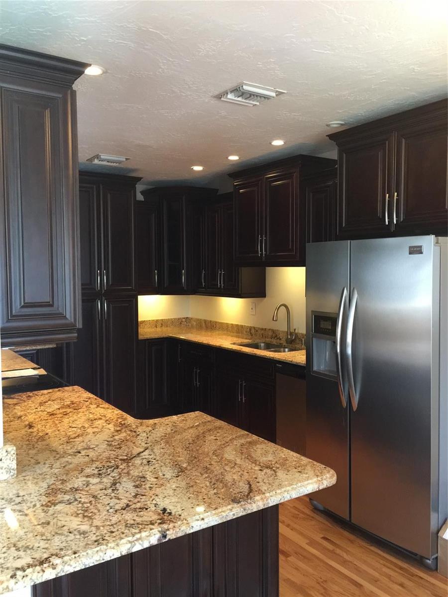 A kitchen features dark wood cabinets, granite countertops, and stainless steel appliances — 2910 SW 103rd Place, Miami FL 33165, MIAMI, FL