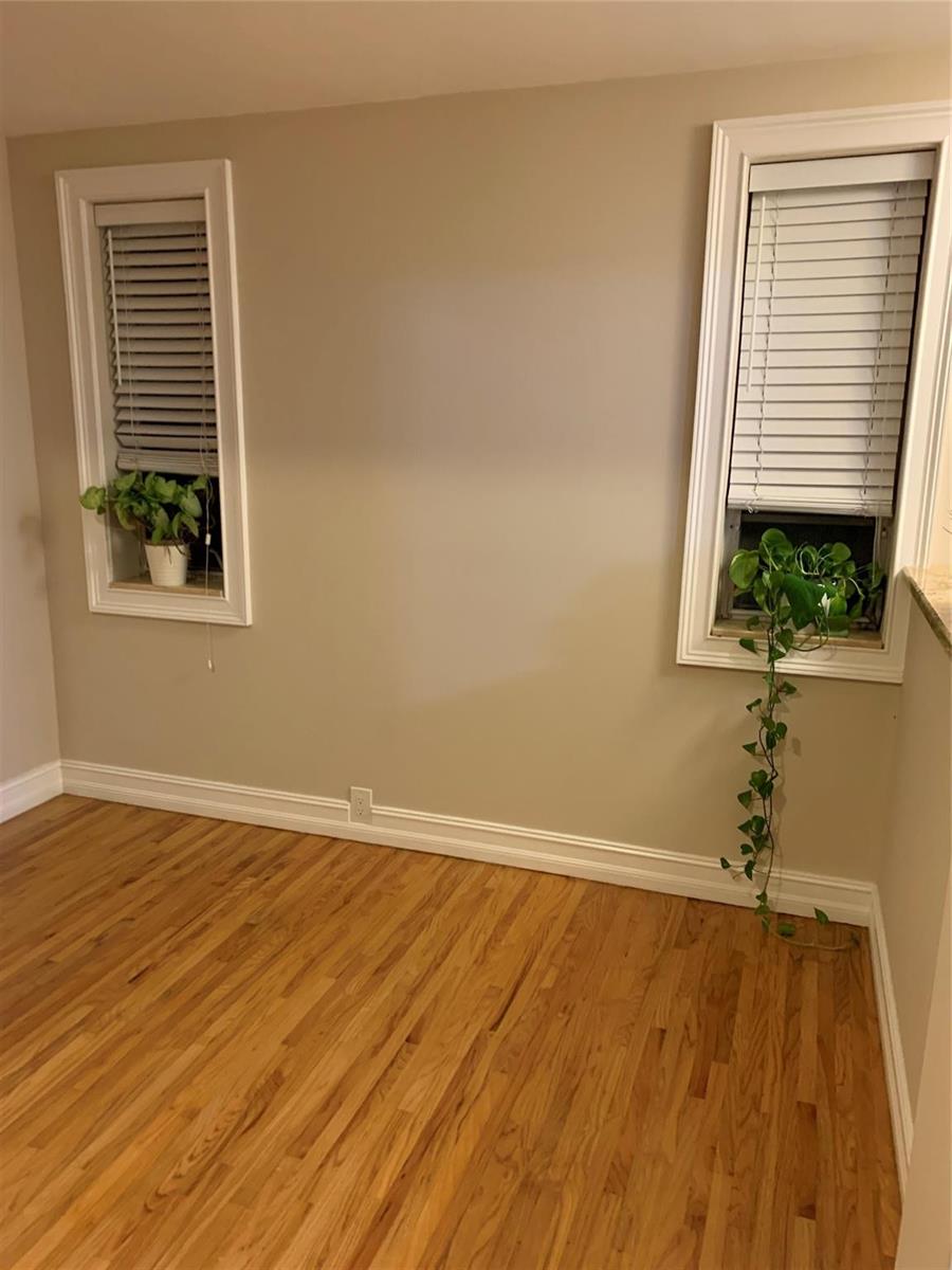 An empty room with hardwood floors, beige walls, and two windows with white blinds — 2910 SW 103rd Place, Miami FL 33165, MIAMI, FL