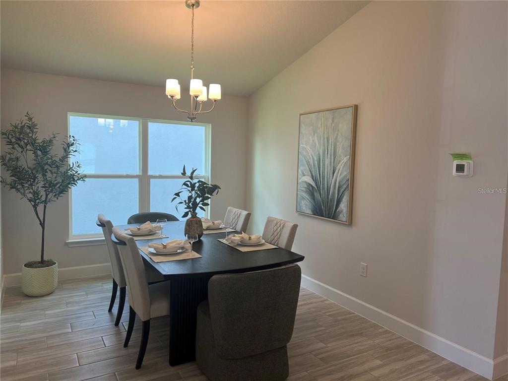 A dining room features a dark wooden table, six chairs, a chandelier, and wall art — 9393 HIGHLAND HILLS DR STREET, HUDSON, FL