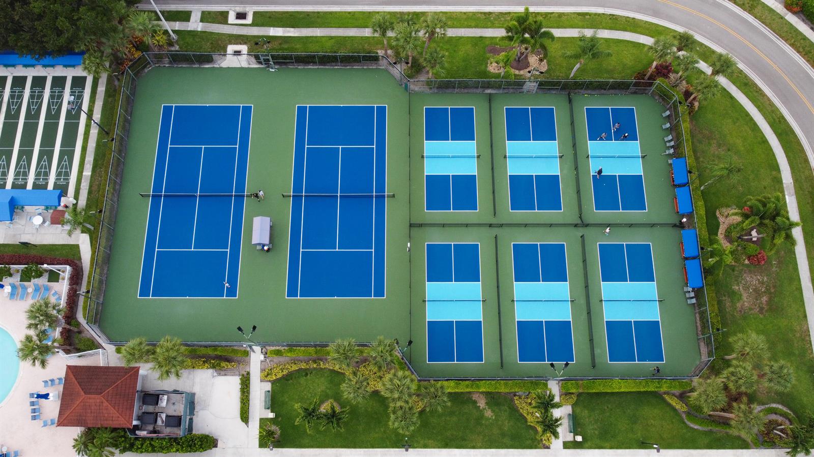 An aerial view shows two tennis courts and six pickleball courts surrounded by landscaped grounds — 5135 Floria Drive # G, Boynton Beach FL 33437, BOYNTON BEACH, FL