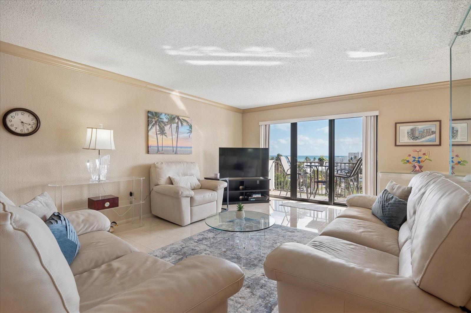 A living room with white leather sofas, a glass coffee table, and a balcony view — 1201 S Ocean # 704s, Hollywood FL 33019, HOLLYWOOD, FL