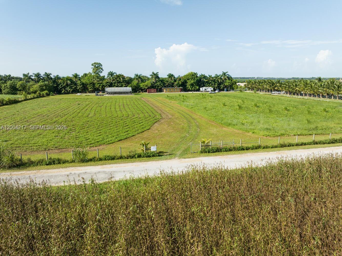 An aerial view of a large, flat, grassy agricultural lot with a gravel driveway — 21750 SW 226 terrace, FL 33170, FL