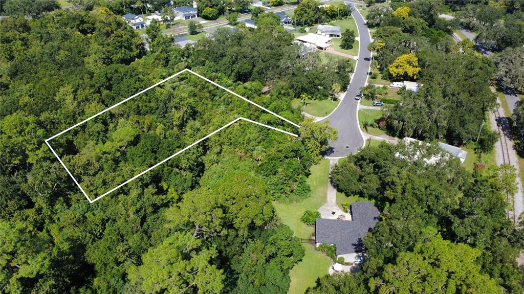 An aerial view shows a wooded residential lot outlined in white next to a house — 2016 GRANDVIEW AVENUE N, SANFORD, FL