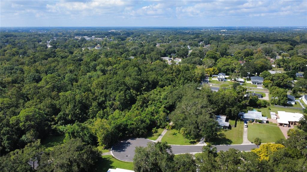 An aerial view shows a residential cul-de-sac surrounded by dense forest and suburban homes — 2016 GRANDVIEW AVENUE N, SANFORD, FL