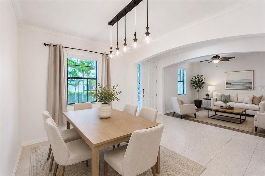 A dining room with a wooden table and pendant lights opens into a living area — 360 HOPE BAY LOOP, APOLLO BEACH, FL