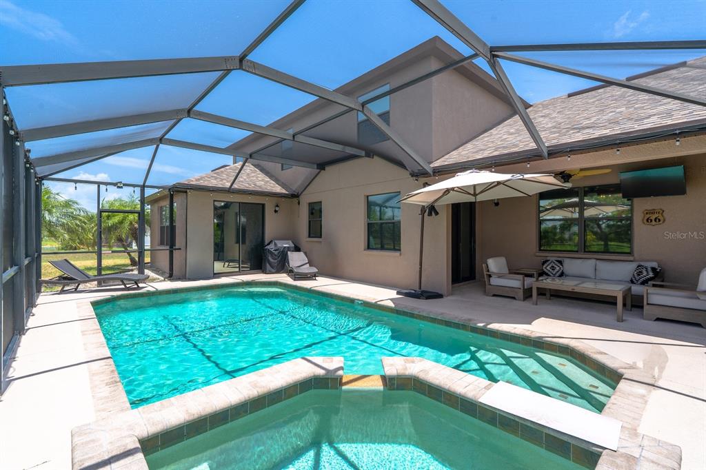 A screened-in patio features a swimming pool, a hot tub, and outdoor seating — 360 HOPE BAY LOOP, APOLLO BEACH, FL