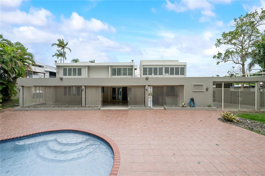 A two-story house exterior features a tiled patio, a swimming pool, and vertical slat fencing — Street #1 STREET #1 TINTILLO HILLS URB. UNIT 606, GUAYNABO, PR