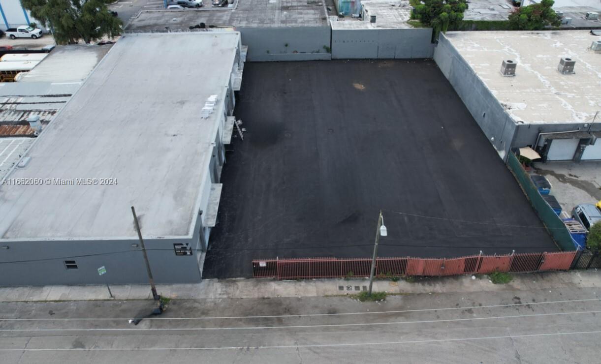 An aerial view shows a paved lot situated between two industrial buildings with a gated entrance — 1740 NW 22nd St, Miami FL 33142, MIAMI, FL