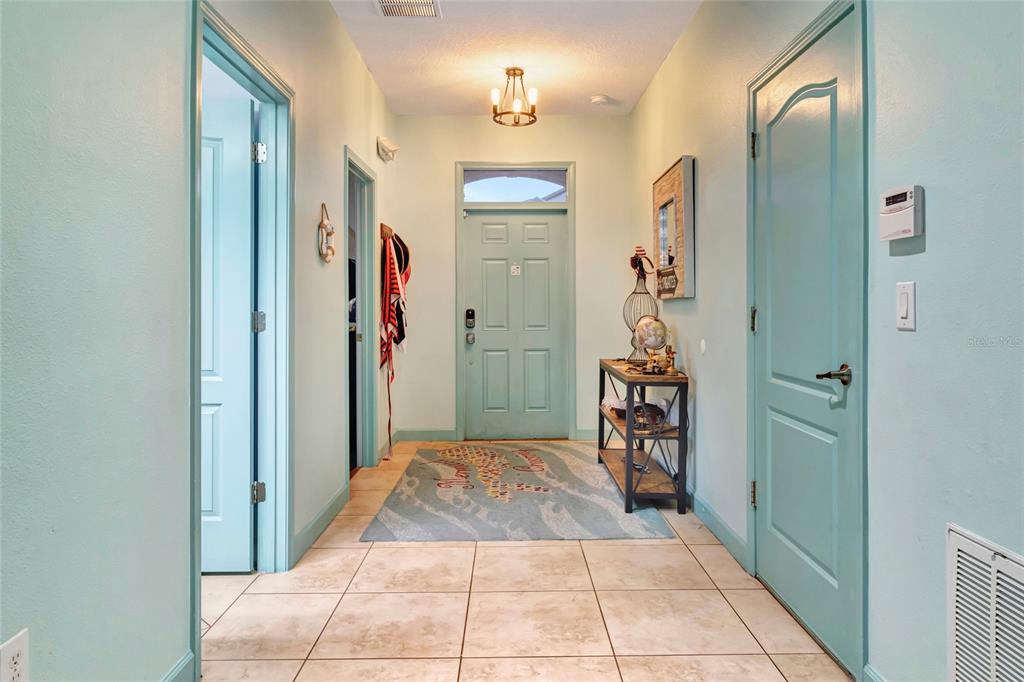 A light blue entryway features tile flooring, a front door with a transom, and furniture — 1424 WEXFORD WAY, DAVENPORT, FL
