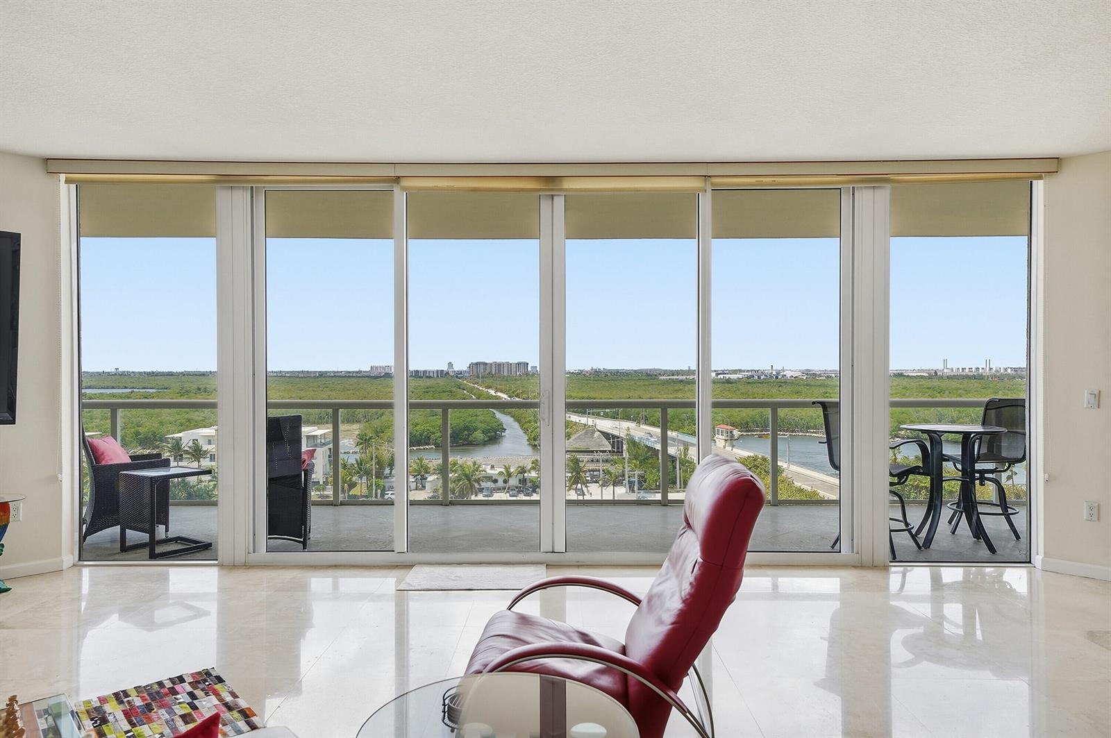 A bright living room features large sliding glass doors opening to a balcony with water views — 6051 N Ocean Drive # 1003, Hollywood FL 33019, HOLLYWOOD, FL