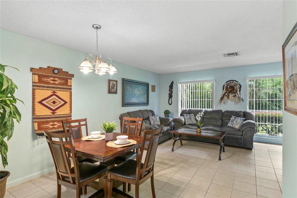 A dining area with a wooden table and chairs sits adjacent to a living room — 1507 GROVE STREET, MAITLAND, FL