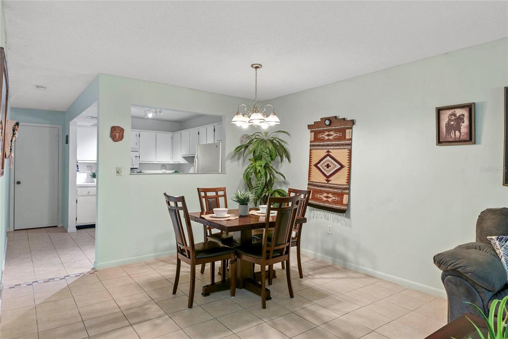 A dining area features a wooden table with four chairs, a hanging light, and wall decor — 1507 GROVE STREET, MAITLAND, FL