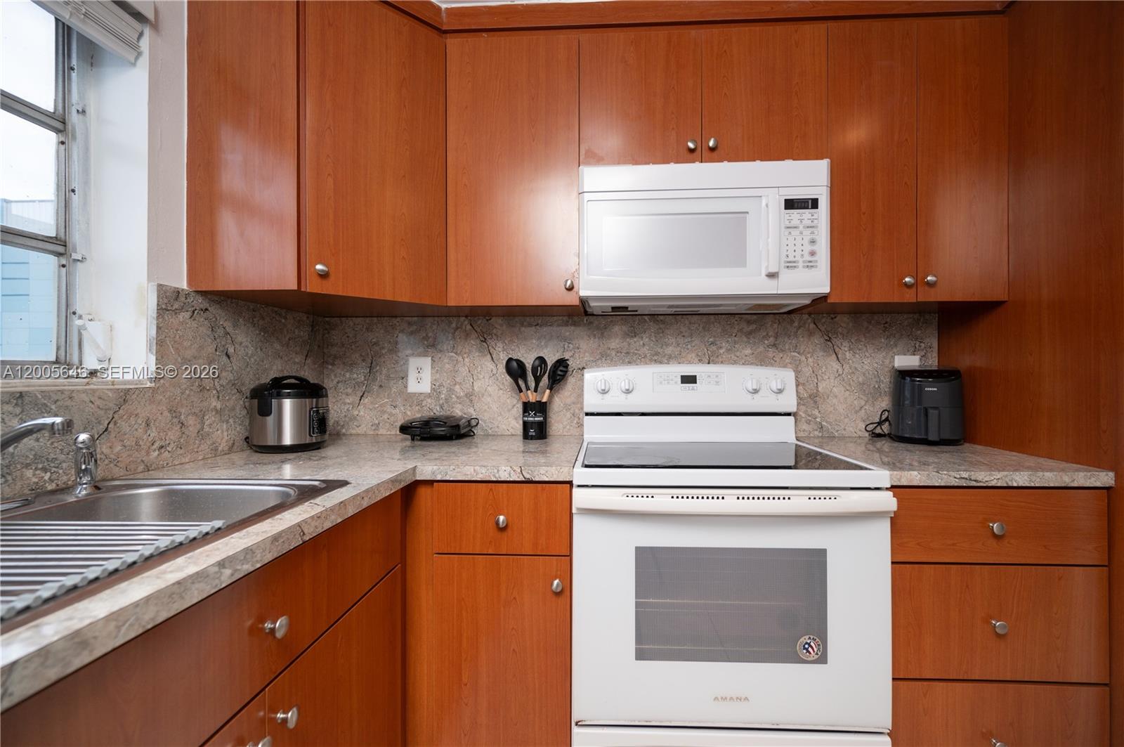 A kitchen features wood cabinets, white appliances, and a stone-look laminate countertop — 500 NE 26th St # 5D, Miami FL 33137, MIAMI, FL