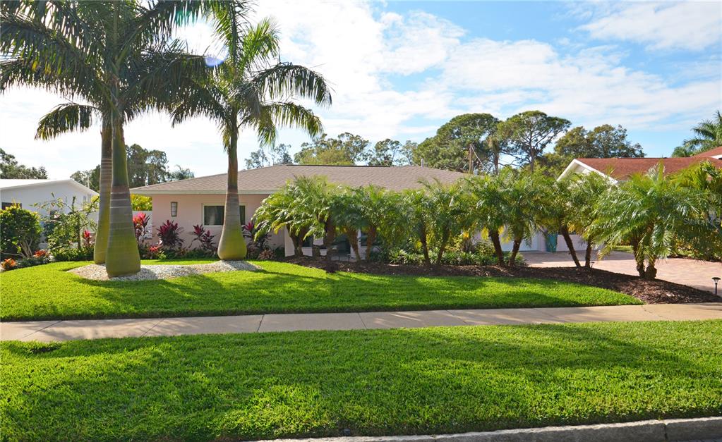 A pink single-story house with a palm-lined front yard and a paved driveway — 7020 MANGO AVENUE S, ST PETERSBURG, FL