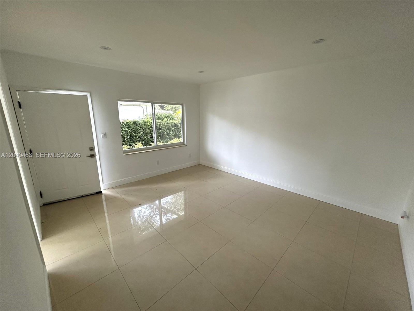 An empty room features white walls, recessed lighting, and light-colored square floor tiles — 1530 NE 110th Ter # A3, Miami FL 33161, MIAMI, FL