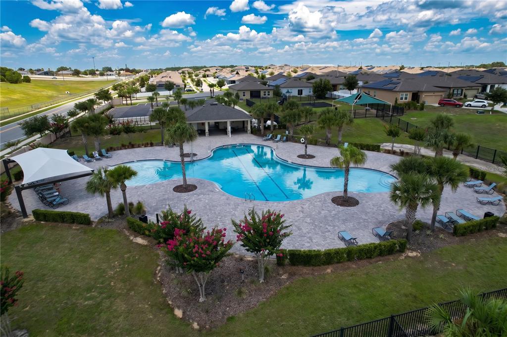 An aerial view of a community swimming pool with a pavilion and surrounding lounge chairs — 148 LUDISIA LOOP, DAVENPORT, FL