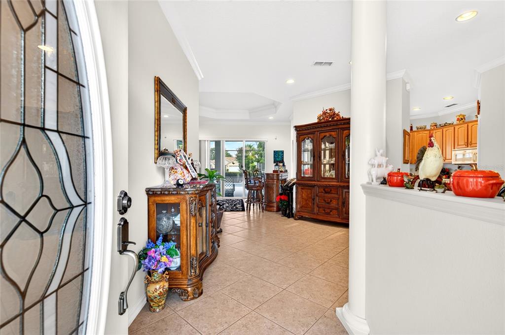 An entryway leads into a tiled living area with a wooden hutch and kitchen view — 8616 SW 82ND TERRACE, OCALA, FL