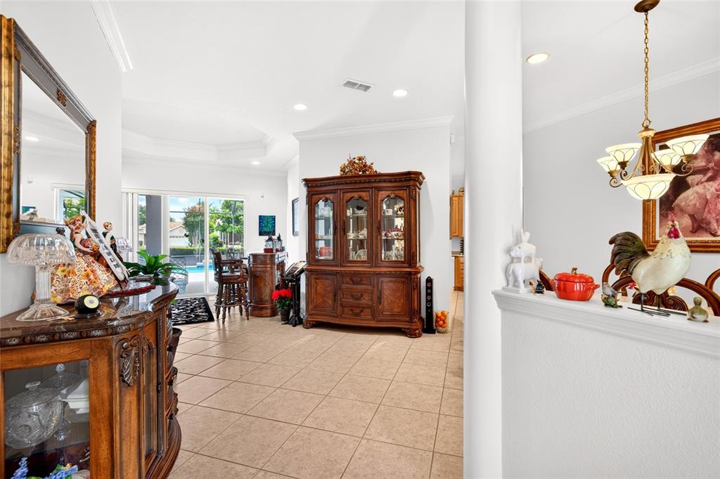 A tiled dining area features a large wooden hutch, a chandelier, and a pool view — 8616 SW 82ND TERRACE, OCALA, FL